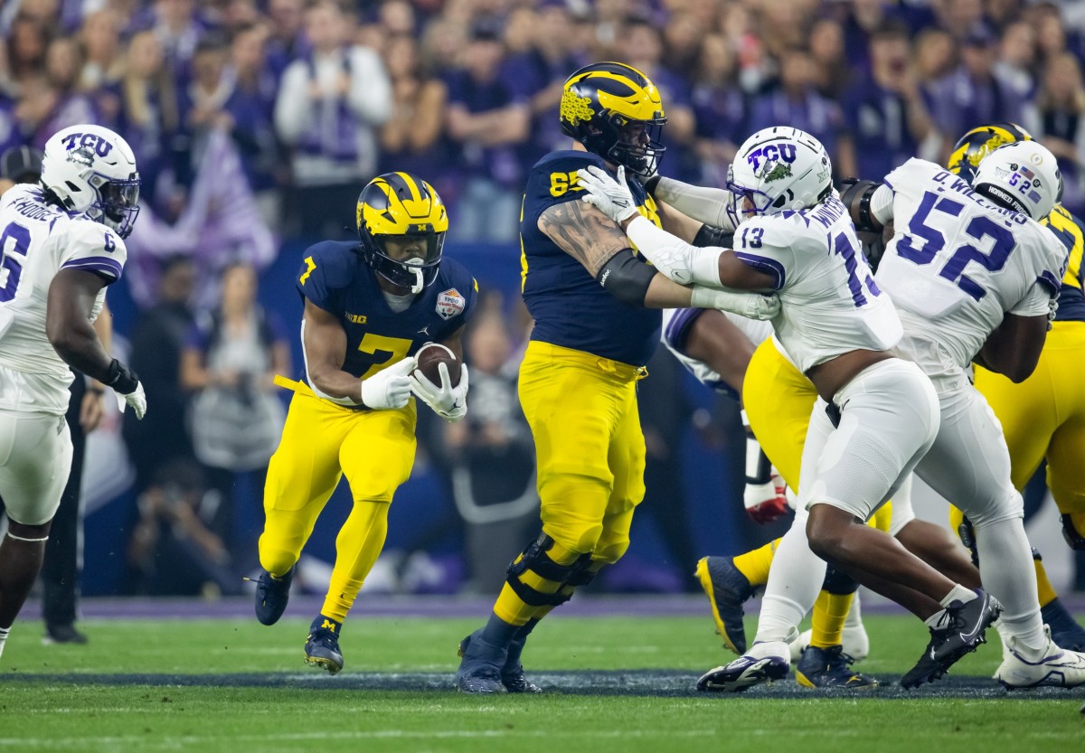 Dec 31, 2022; Glendale, Arizona, USA; Michigan Wolverines running back Donovan Edwards (7) runs the ball as offensive lineman Zak Zinter (65) blocks TCU Horned Frogs linebacker Dee Winters (13) during the 2022 Fiesta Bowl at State Farm Stadium. Mandatory Credit: Mark J. Rebilas-USA TODAY Sports  